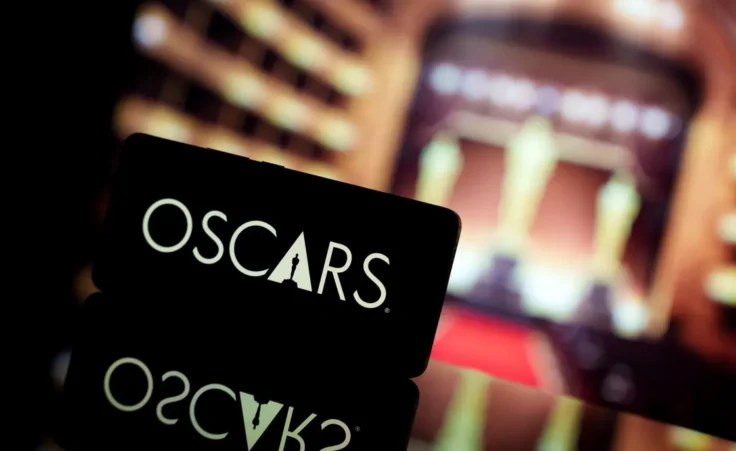 A smartphone displaying the Oscars logo against a blurred awards ceremony background. By Rokas/stock.adobe.com