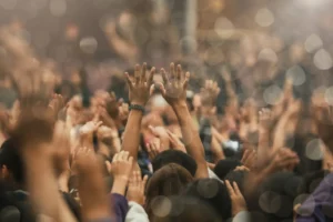 Christian worship gathering with raised hands praising God. By DeeKaren/stock.adobe.com. Maudy Thursday revival gen z