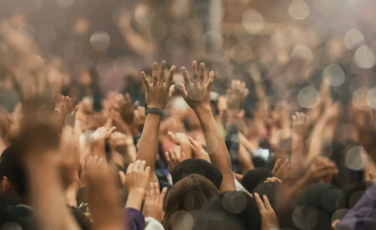 Christian worship gathering with raised hands praising God. By DeeKaren/stock.adobe.com. Maudy Thursday revival gen z