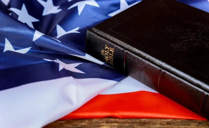 United States Flag and Bible on a distressed wood background. By ungvar/stock.adobe.com. America reads the Bible