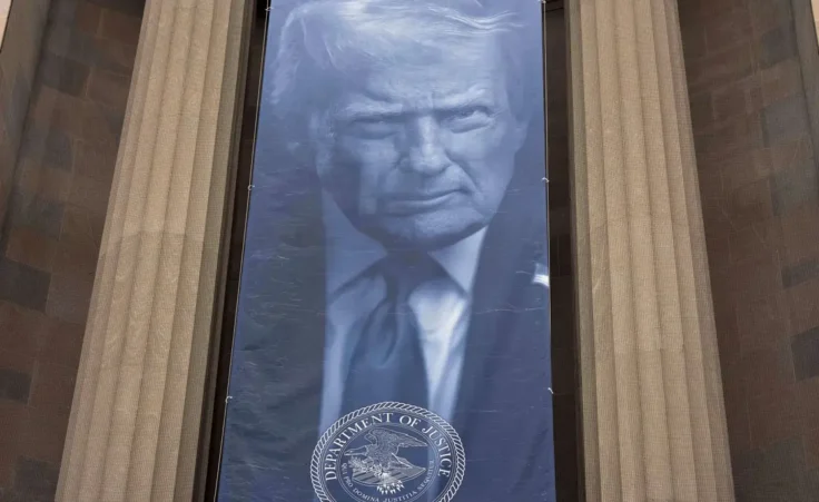 A banner with a portrait of President Donald Trump is hung from the Department of Justice, Thursday, March 5, 2026, in Washington. (AP Photo/Jose Luis Magana)