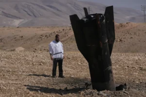 A man look at the wreckage of an Iranian missile that landed near the West Bank city of Jericho Monday, June 8, 2026. (AP Photo/Mahmoud Illean) Israel Iran