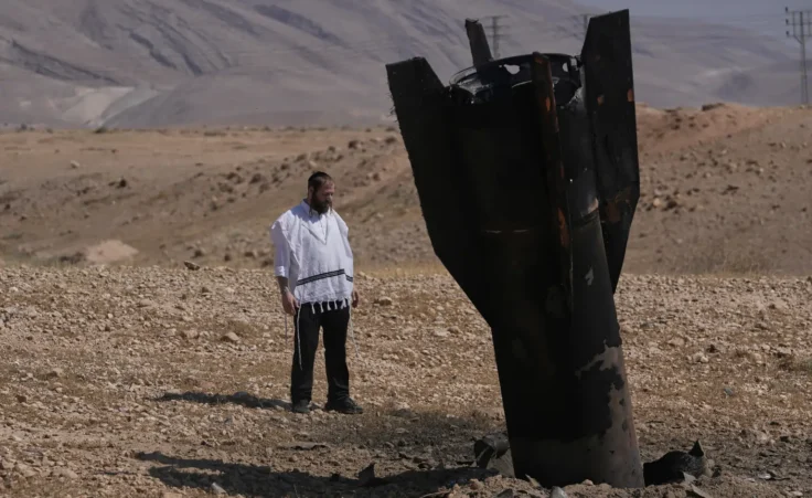 A man look at the wreckage of an Iranian missile that landed near the West Bank city of Jericho Monday, June 8, 2026. (AP Photo/Mahmoud Illean) Israel Iran