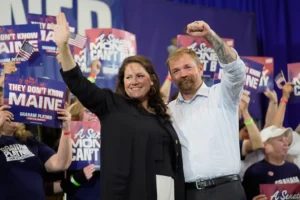 Democratic U.S. Senate candidate Graham Platner, right, and his wife Amy Gertner gesture to supporters during a primary election night watch party Tuesday, June 9, 2026, in Blue Hill, Maine. (AP Photo/Robert F. Bukaty)