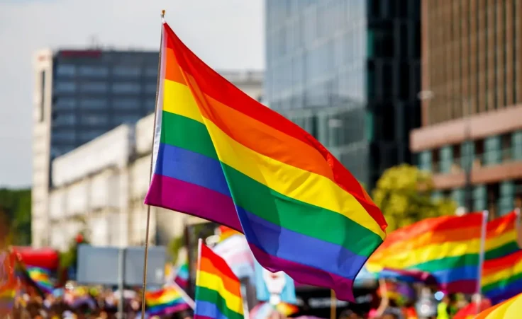 Lgbt pride rainbow flag during parade in the city . By 9parusnikov/stock.adobe.com