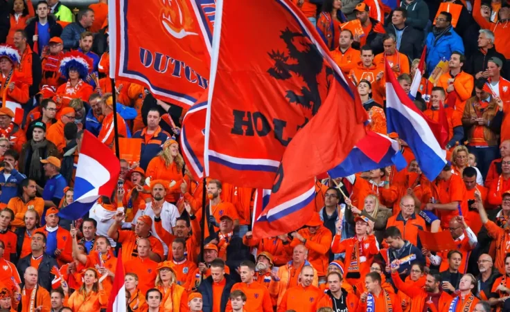 Dutch fans clad in the traditional orange colors of the team wave flags prior to the World Cup Group A qualifying soccer match in the ArenA stadium in Amsterdam, Netherlands, Monday, Oct. 10, 2016. (AP Photo/Peter Dejong)