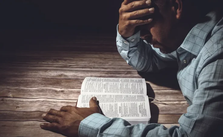 Worried man reading the Holy Bible by JavierArtPhotography/stock.adobe.com
