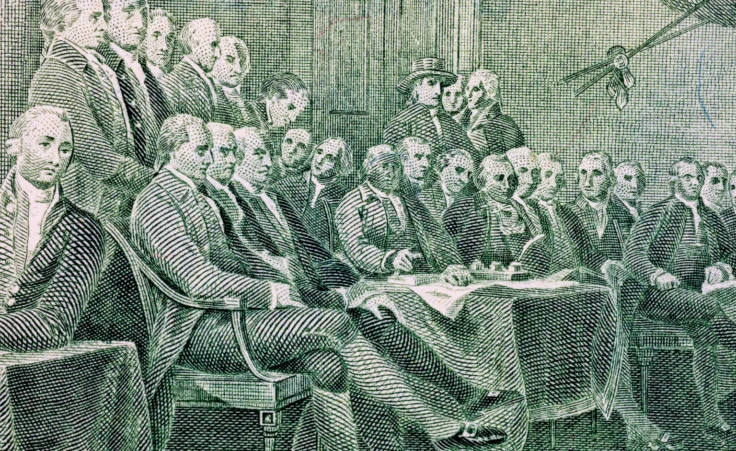 Detail of the $2 bill's reverse side, which shows the signing of the Declaration of Independence. By Sergii/stock.adobe.com. John Adams Independence Day July