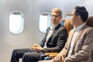 Two men having a conversation on an airplane. By Akarawut/stock.adobe.com. Christians share the gospel on airplanes