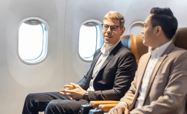 Two men having a conversation on an airplane. By Akarawut/stock.adobe.com. Christians share the gospel on airplanes