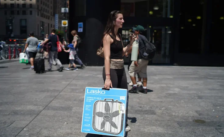 A woman carries a portable fan during an extreme heatwave in New York on Friday, July 3, 2026. (AP Photo/Ryan Murphy)